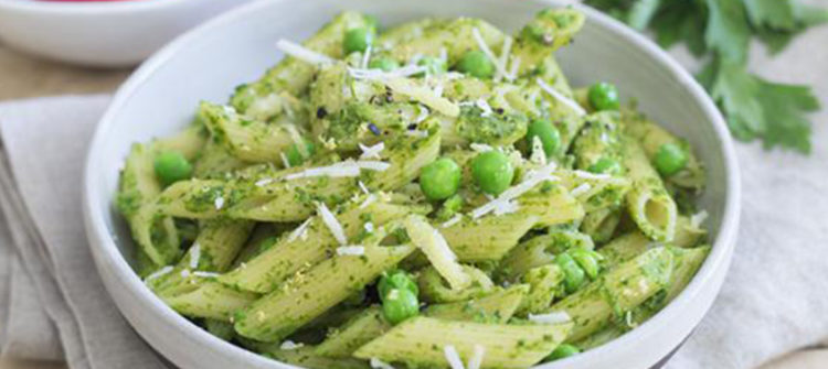 a photo of a bowl of pasta covered with pesto