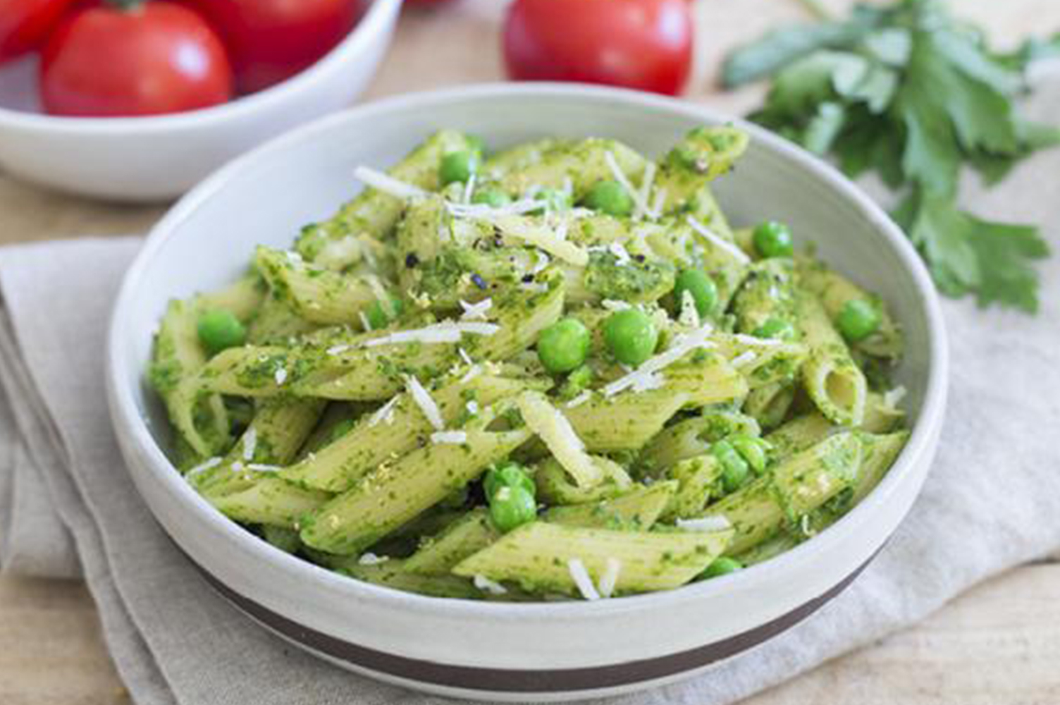 a photo of a bowl of pasta covered with pesto