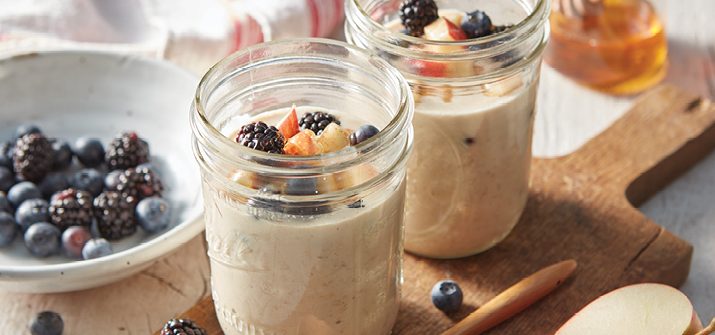 Two mason jars filled with oats topped with berries