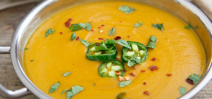 a bowl of kabocha squash soup topped with jalapenos